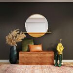 brown wooden framed brown padded armchair beside blue and white round mirror