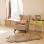 wing chair beside suitcase and window